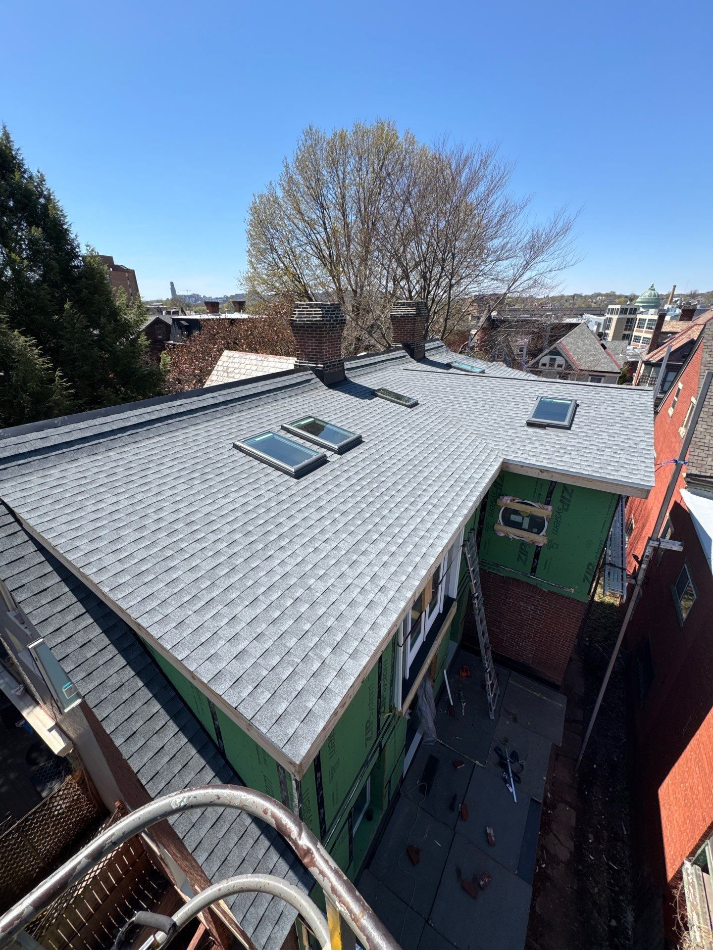City rooftop with new shingles and three skylights over a ZIP System sheathed addition