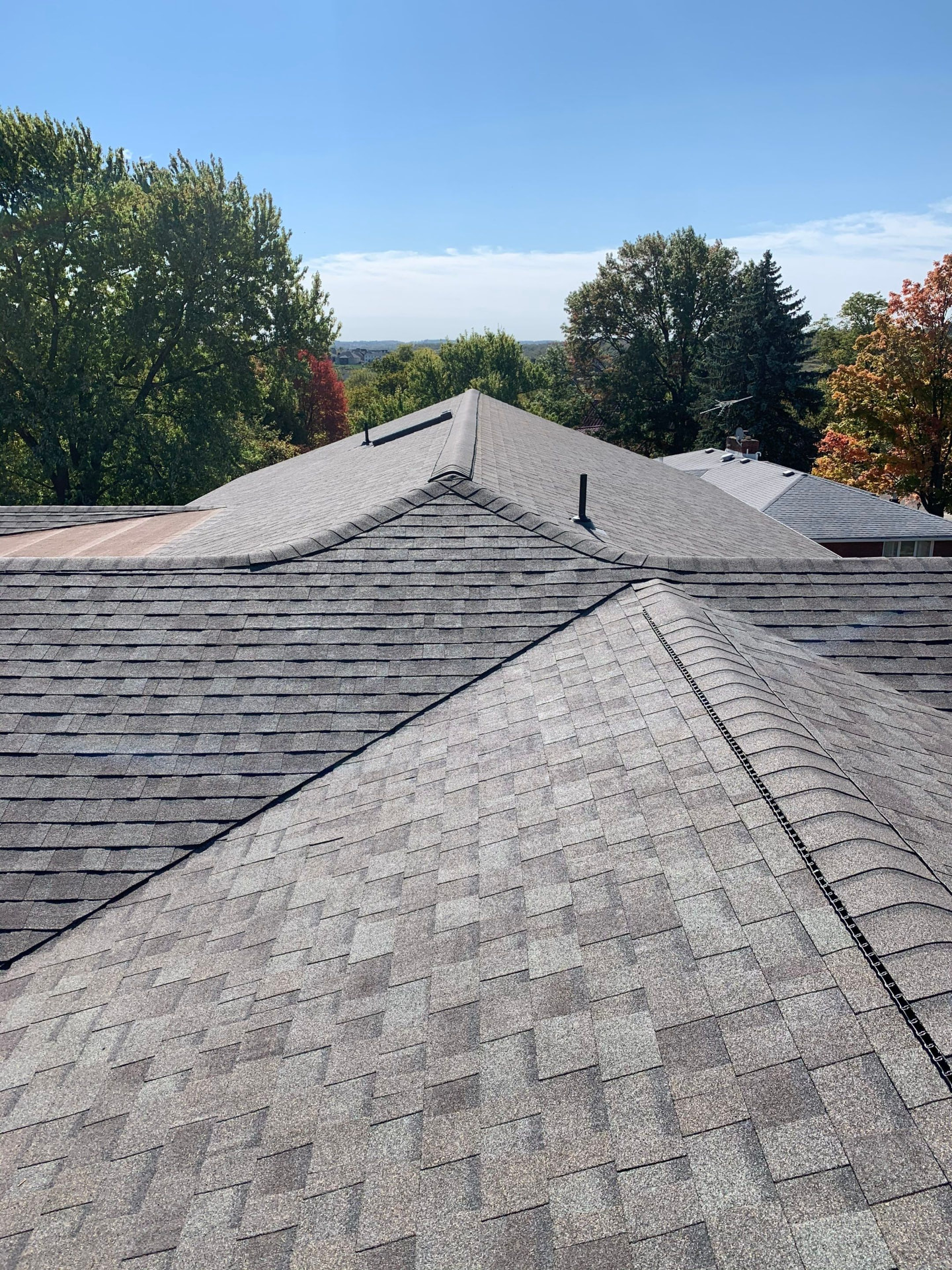 Finished charcoal shingle hip roof with new ridge vent on a Pittsburgh-area home